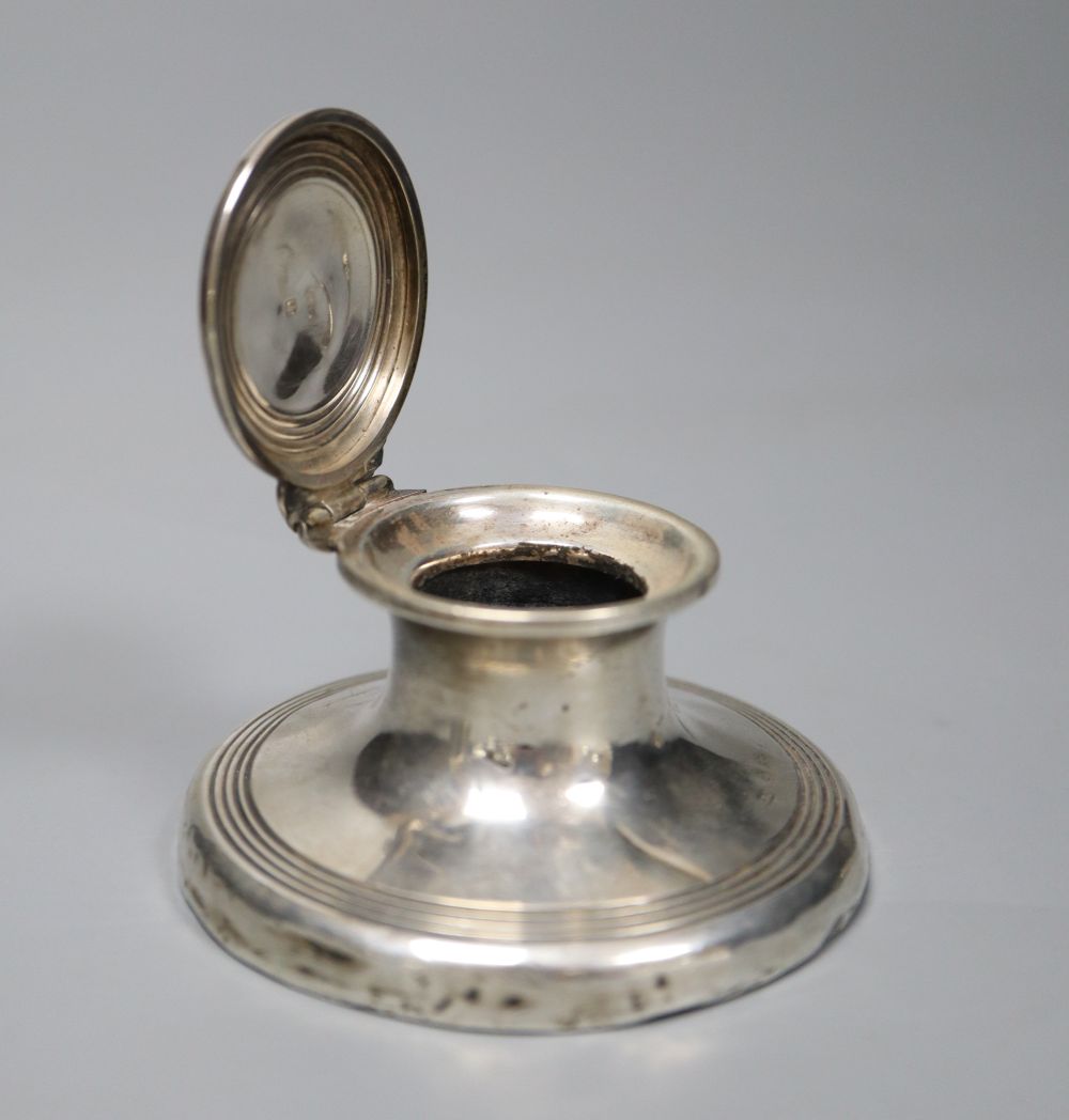 A silver capstan inkwell and two silver-cased cylindrical scent bottles